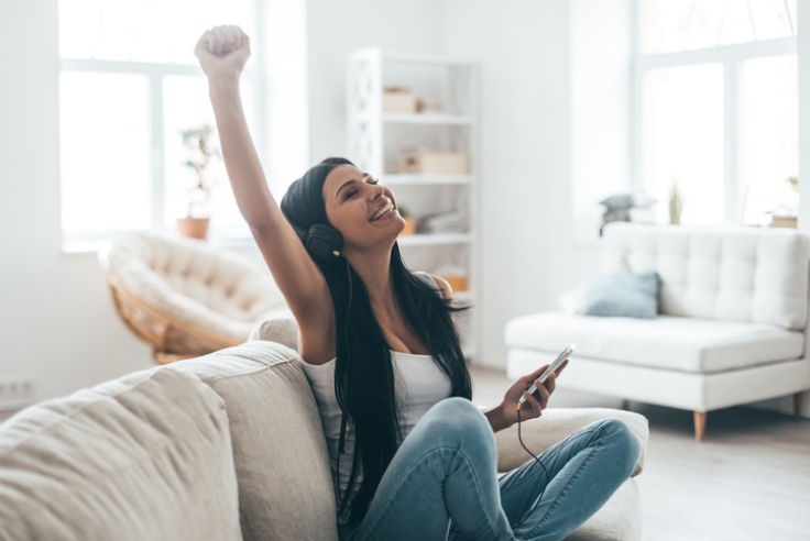 Femme en train d'écouter de la musique sur son canapé